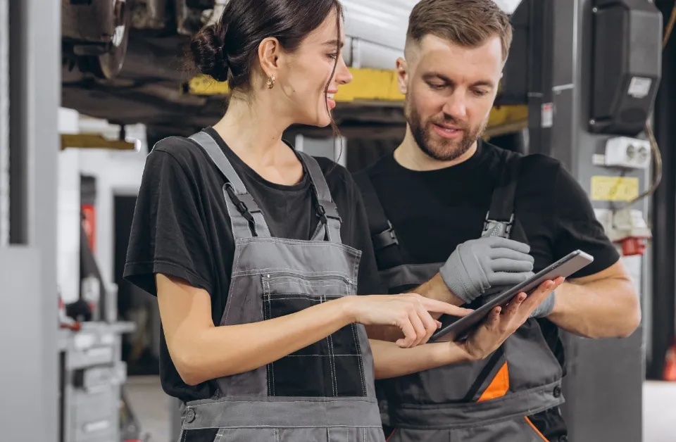 Zwei KFZ-Mechaniker schauen auf ein Tablet