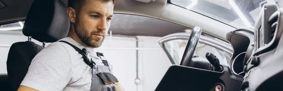 Mechaniker führt eine Analyse im Inneren eines PKW durch